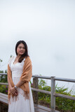 Fototapeta Krajobraz - A woman white dress and brown 
cloth cover standing alone at Fog background in Phetchabun Province, Thailand.