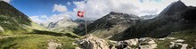 Panoramic View Of Mountains Against Sky And Swiss Flag