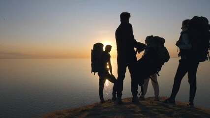 Wall Mural - the people with backpacks standing on the mountain top near the sea. slow motion