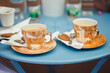 Kawa w filiżankach i piernik na niebieskim stoliku w kawiarni