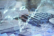 © peshkova - Double exposure of financial chart drawings and desk with open notebook background. Concept of forex market