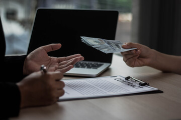 Two Asian business women are making bribes. They corrupt the company. They agreed to talk in a private office.