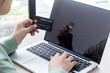 © kamiphotos - Asian business women are keying in their credit card details to pay online. She is in the office.