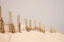 Wooden Fence On Sand At Beach Against Clear Sky