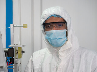 Portrait of engineer worker in protective suits, masks, and gloves in the manufacture of surgical masks for coronavirus..