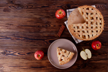 Wall Mural - Traditional American Thanks Giving pie with whole organic apples, cinnamon sticks on wooden table. Homemade fruit tart baked to golden crust. Close up, copy space, top view, background.