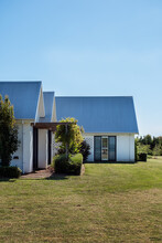 White Brick Country Homestead With Tall Pitched Roofline And Copyspace