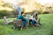© Trinette Reed/Stocksy - Couple sitting at outdoor fire pit