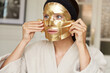 © Leandro Crespi Studio/Stocksy - Young woman applying golden face mask