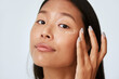 © Leandro Crespi Studio/Stocksy - Woman applying under eye corrector