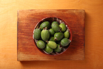 feijoa in a bowl on a wooden background. Flat lay.