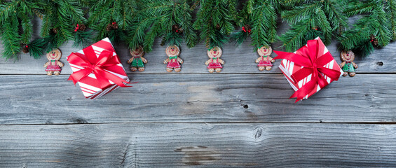 Wall Mural - Christmas rustic natural wooden background with fir branches and gingerbread cookie figures plus giftboxes