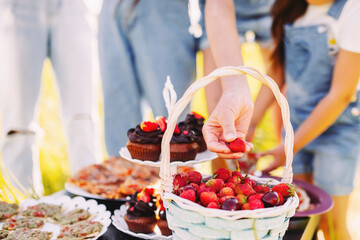 A picnic for children in nature, a table with muffins and cakes, homemade pizza, food for a family holiday