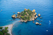 Aerial view of island and Isola Bella beach with people and a nearby boat near Taormina, Sicily, Italy