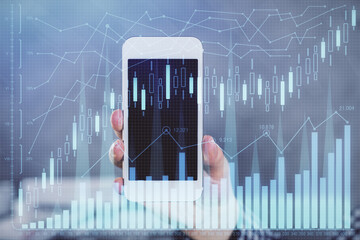 Double exposure of man's hands holding and using a digital device and forex graph drawing. Financial market concept.