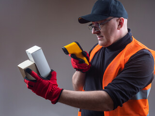 Poster - Warehouse storage. A man in work clothes reads barcodes from cardboard boxes. Marking of goods. Warehouse account. Delivery of goods from the warehouse.