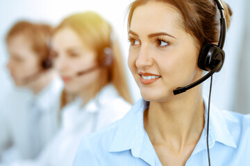 Call center. Focus on beautiful business woman in headset