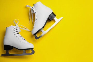 Wall Mural - pair of figure ice skates on yellow background, flat lay. space for text