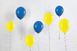 © New Africa - Many balloons in colors of Ukrainian flag near white brick wall