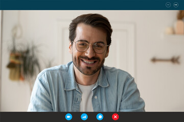 Head shot laptop screen view handsome young 30s man in eyeglasses looking at camera, enjoying pleasant distant online conversation, communicating by video call computer software application indoors.