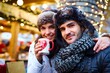 © nyul - Closeup portrait of young loving couple drinking hot drink at christmas time on the street.