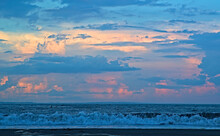 Colorful Twilight View Of Layers Of Clouds Over The Ocean From Katase Higashihama Beach, With A Lone Surfer Visible