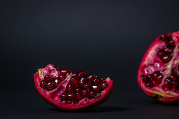 Pomegranate on a black background. Cut Pomegranate. Red fruit