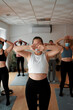 Group of women with masks practicing pilates exercises in class safely