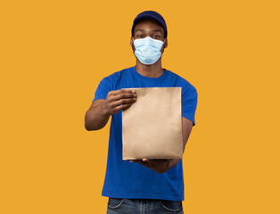 Wall Mural - Black delivery guy in medical face mask holding package