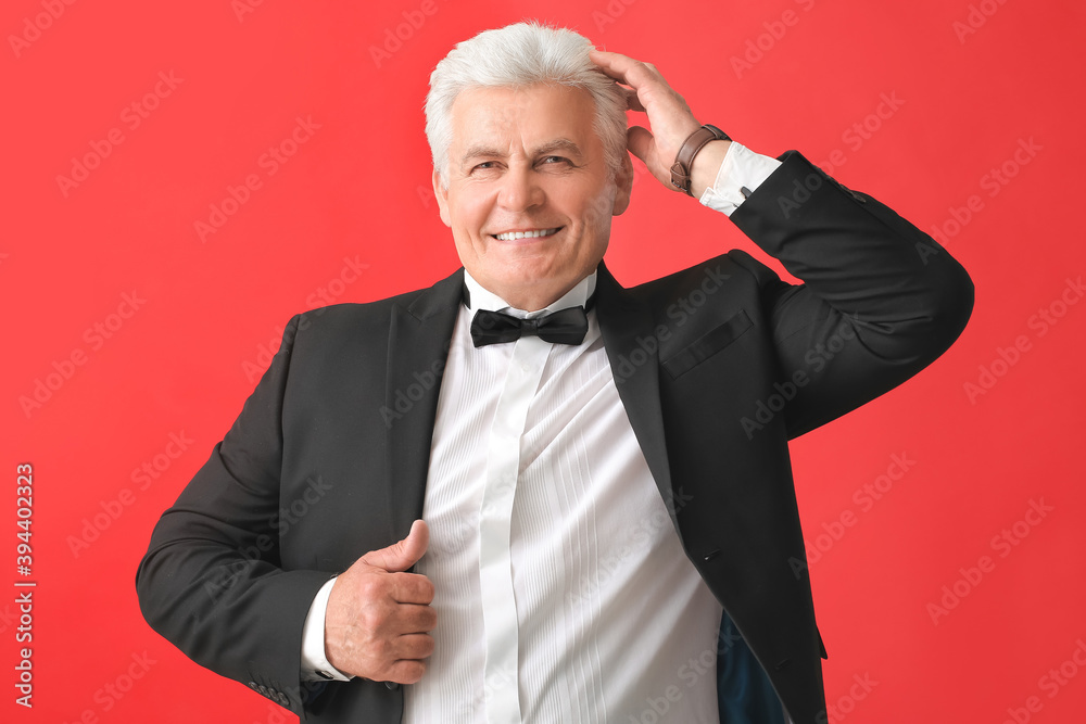 Stylish senior man on color background