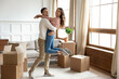 © fizkes - Husband lifts up wife celebrate relocation day to new home. Young married couple move to bought own flat feels incredible happy and proud. Unpacked carton boxes symbol of bank loan, mortgage concept