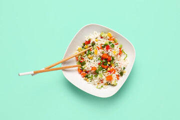 Plate of delicious rice salad with vegetables on color background