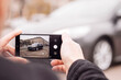 © Екатерина Шелудько - a man takes pictures of a car on the phone in the middle of the city