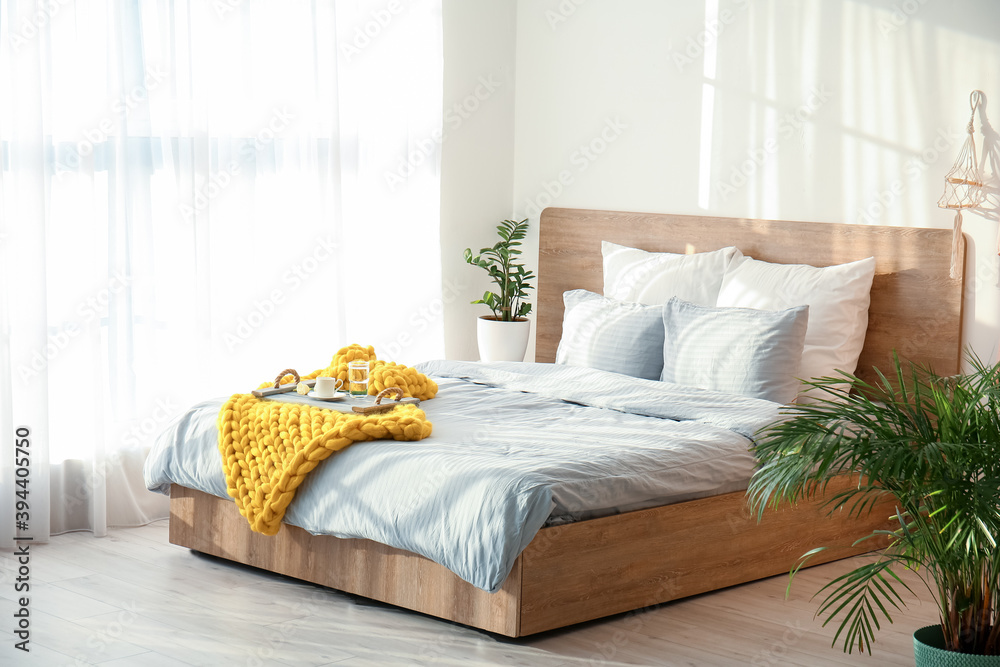 Knitted plaid with breakfast on bed at home