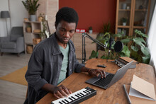 Portrait Of Young African-American Man Composing Music In Home Recording Studio, Copy Space