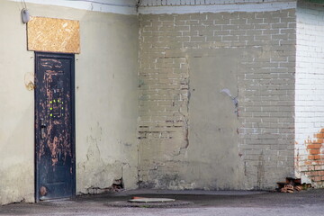 Two textured walls on the corner of the house and an old door