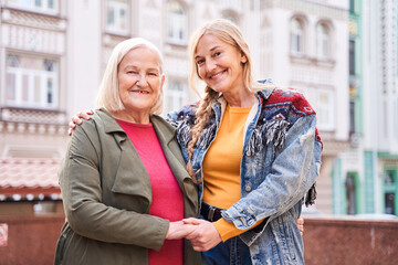 Woman standing at the street with her blonde adult daughter