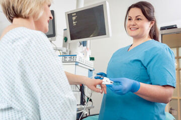 Canvas Print - Nurse preparing blood pressure sensor for surgery on patient