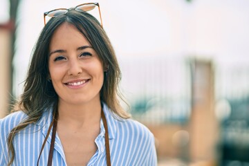 Young hispanic woman smiling happy standing at the city.