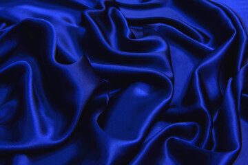 dark blue silk wavy fabric background, view from above. smooth elegant blue silk or satin luxury clo
