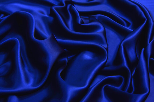 Wall Mural -  - Dark blue silk wavy fabric background, view from above. Smooth elegant blue silk or satin luxury cloth texture using as abstract background for design, close-up