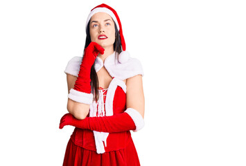 Poster - Young beautiful caucasian woman wearing santa claus costume with hand on chin thinking about question, pensive expression. smiling and thoughtful face. doubt concept.