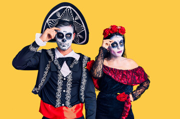 Canvas Print - Young couple wearing mexican day of the dead costume over background worried and stressed about a problem with hand on forehead, nervous and anxious for crisis