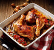 © zi3000 - Roasted chicken leg quarters  with herbs and spices served in a baking dish on a wooden table close up view