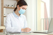 © White bear studio  - young womanl doctor in a medical mask in the interior of the office