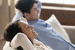 © fizkes - Lazy leisure. Smiling content young husband and wife resting relaxing at home leaning back on cozy sofa at living room having pleasure breathing fresh air dreaming with closed eyes meditating together