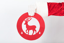 Hand Of Santa Claus With A Reindeer Traffic Sign On White Background. Christmas Concept