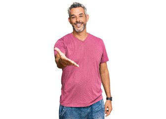 Canvas Print - middle age grey-haired man wearing casual clothes smiling cheerful offering palm hand giving assista