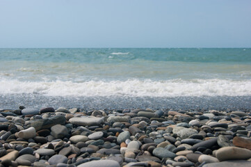 a small storm three or four points at sea, the wave hits the shore with a large pebble. black sea, s