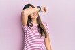© Krakenimages.com - Young brunette woman wearing casual clothes over pink background covering eyes with arm smiling cheerful and funny. blind concept.